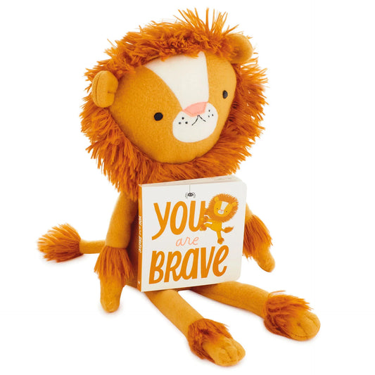 MopTops Lion Plush - You Are Brave with orange fur, holding a motivational board book, sitting pose, plush material.