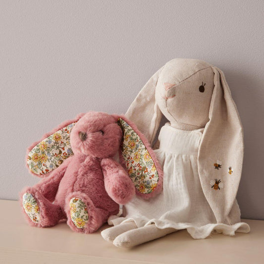 Bessie Bunny plush toy in floral dress with pink companion, showcasing embroidered details and soft materials, flat lay view.