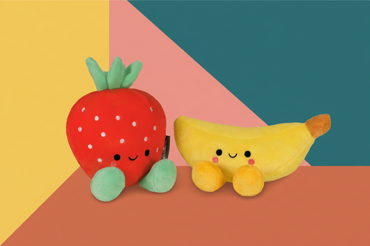 Better Together Strawberry and Banana Magnetic Plush Pair, 5.5" in vibrant colours with smiling faces, angled view on a geometric background.