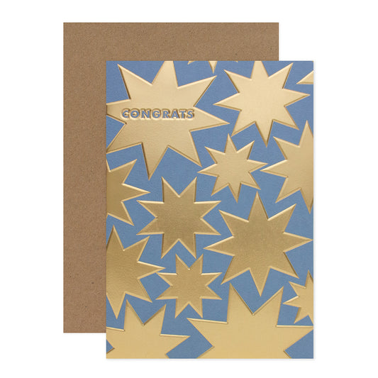 Halcyon by Hallmark Congratulations Card – Gold Stars with gold foil stars on blue, paired with a kraft envelope, flat lay