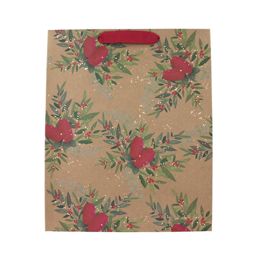 A kraft paper gift bag with a repeating pattern of green leaves, red berries, and red hearts, featuring a solid red handle on a white background.