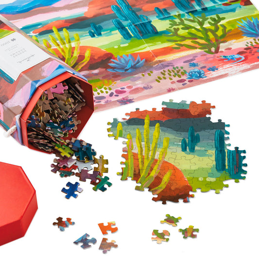 Desert Dreams 1,000-Piece Jigsaw Puzzle in vibrant packaging with scattered puzzle pieces and a partial puzzle layout.