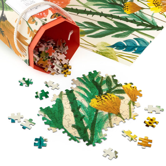 Floral No. 021 1,000-Piece jigsaw puzzle pieces scattered beside the vibrant floral design and hexagonal packaging.