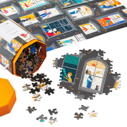 Snapshots of Life 1,000 Piece Jigsaw Puzzle pieces spilling from hexagonal box alongside assembled section showing illustrated window scene.