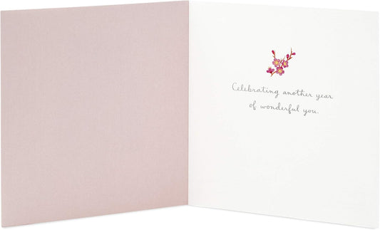 Hallmark Signature Birthday Card for Her (Cake) opened to reveal a soft pink interior with a heartfelt message and floral embellishment.