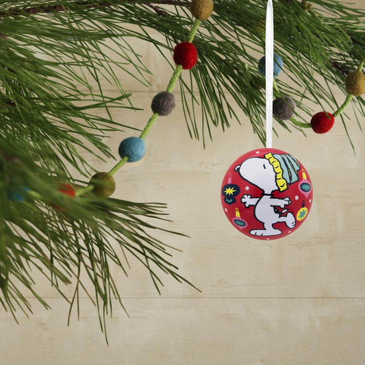Peanuts® Tin Balls, Set of 12 — Hallmark Christmas Ornament featuring Snoopy design, hanging from pine tree branch, colourful background.