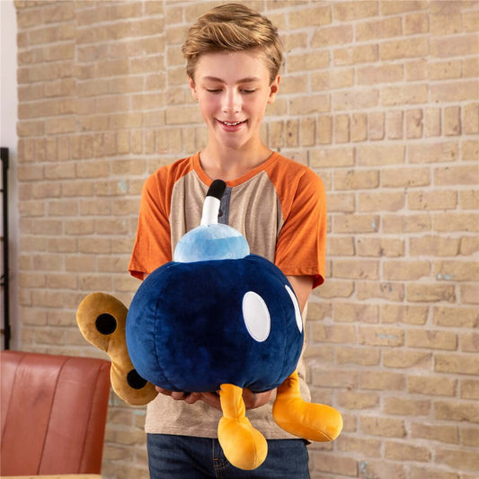 Nintendo Super Mario Bob-omb Mega Mocchi Mocchi plush held by a child, featuring soft fabric and vibrant colours.