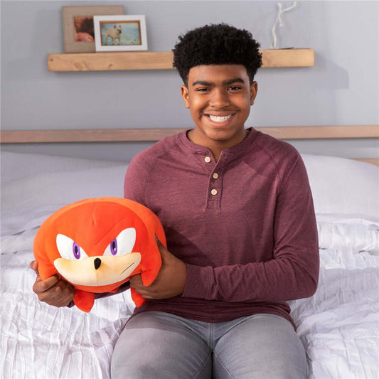 Knuckles MEGA Mocchi Mocchi plush toy held by a smiling teen, demonstrating its large, squishy design and vibrant colour.
