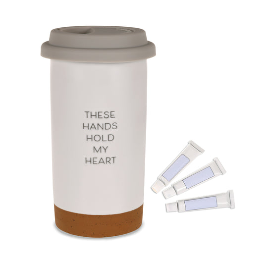 These Hands Hold My Heart Ceramic Travel Mug, 12.5 oz. with grey silicone lid and three paint tubes for DIY decoration.