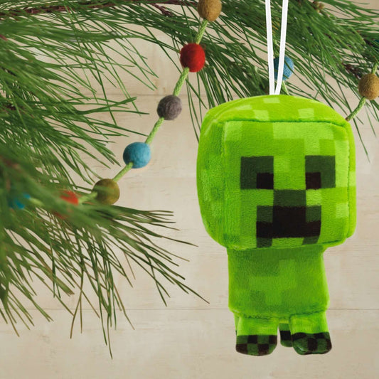 Minecraft Creeper, plush fabric - Hallmark Christmas ornament, hanging from a pine branch with colourful decorations.