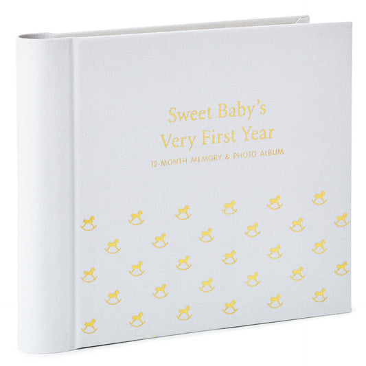 Sweet Baby's First Year Baby Book in soft grey fabric with gold foil design, showcasing rocking horse theme and die-cut photo openings.