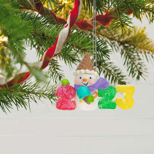 Sweet Decade — Hallmark Keepsake Christmas Ornament, plastic decoration, featuring a snowman with ice cream cone and gumdrop numbers 2023, hanging on a Christmas tree.