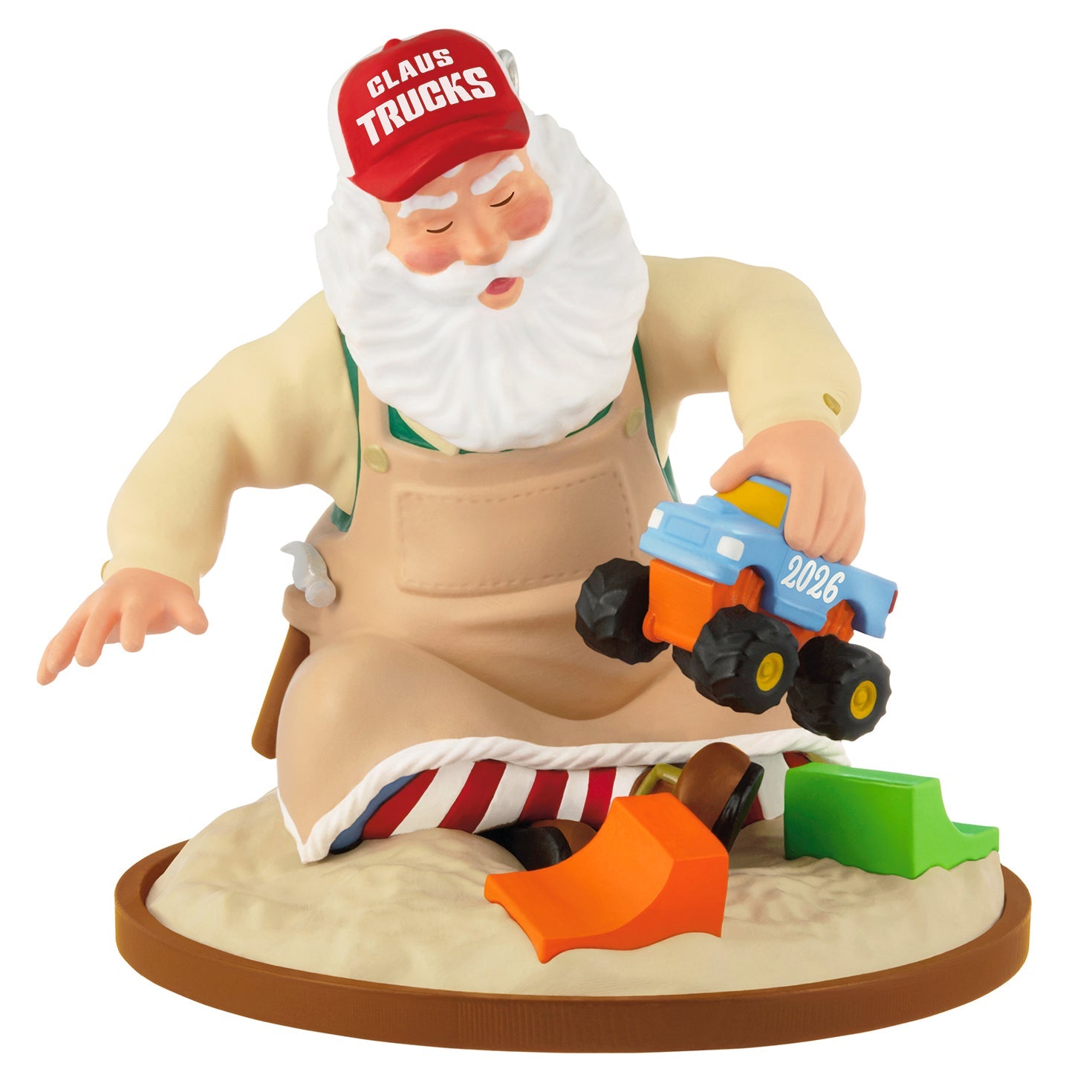 2026 Keepsakes Hallmark Christmas Ornament Collection featuring Santa in an apron, playing with a toy truck. Close up view.