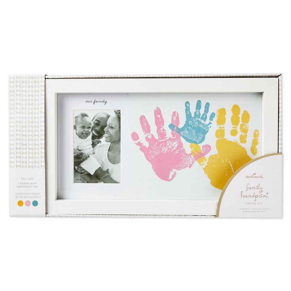 Family handprint and photo frame kit in white frame, featuring colourful handprints and a 4x6 photo space, displayed in packaging.