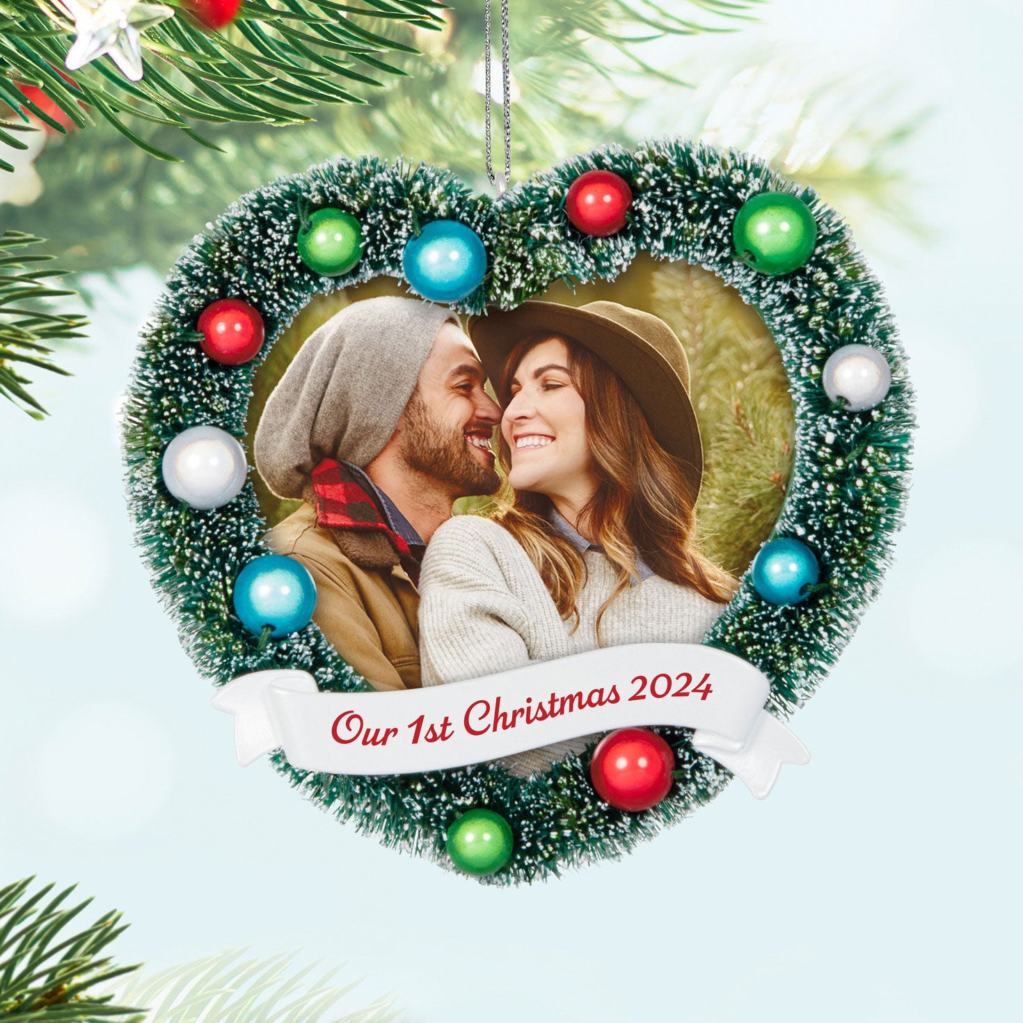 Our 1st Christmas photo frame — Hallmark Keepsake Christmas Ornament with frosted wreath design and colourful ornaments, featuring a couple's smiling photo.