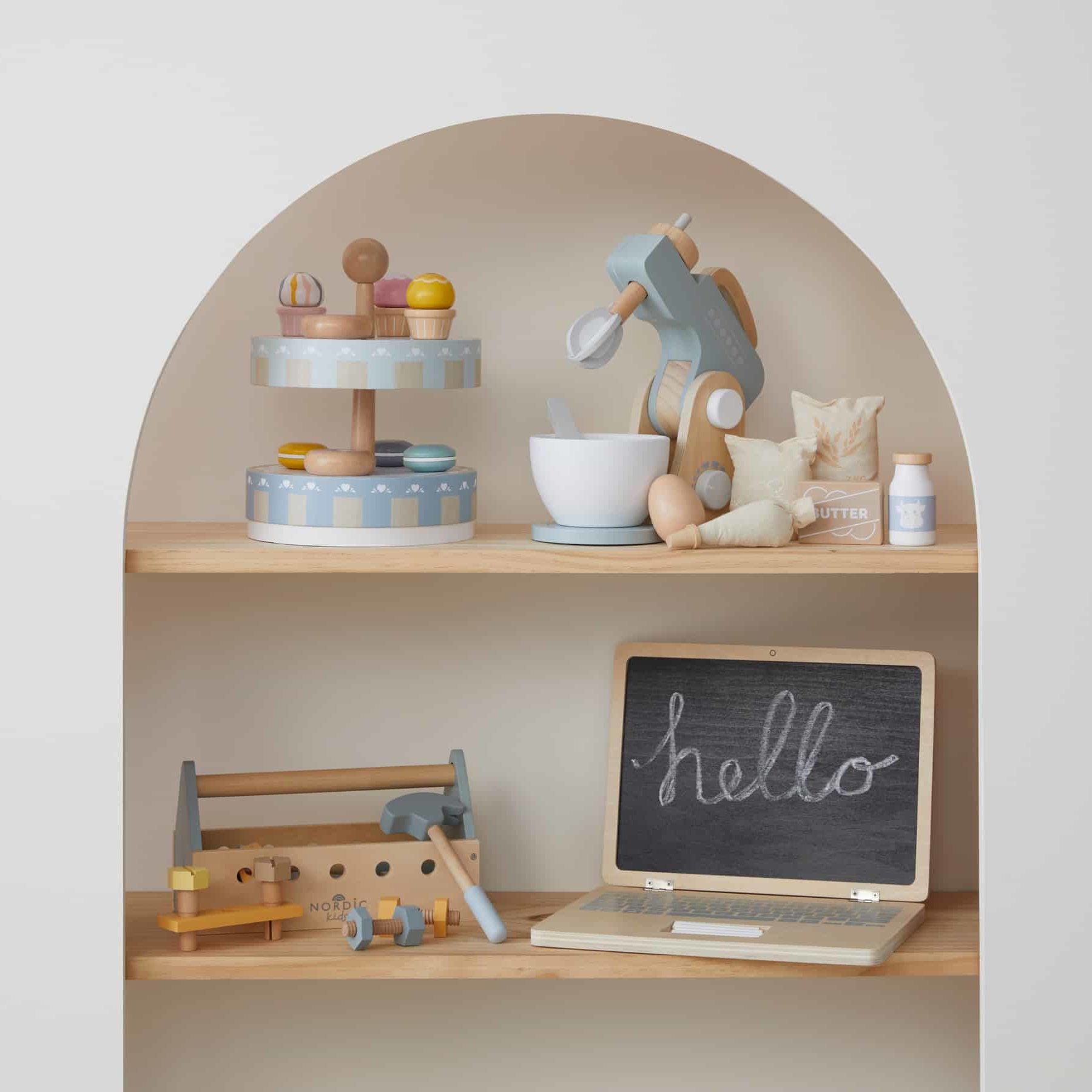 Wooden cake stand set featuring pastel coloured dessert toys on a shelf, with a toy mixer and chalkboard in a stylish playroom.
