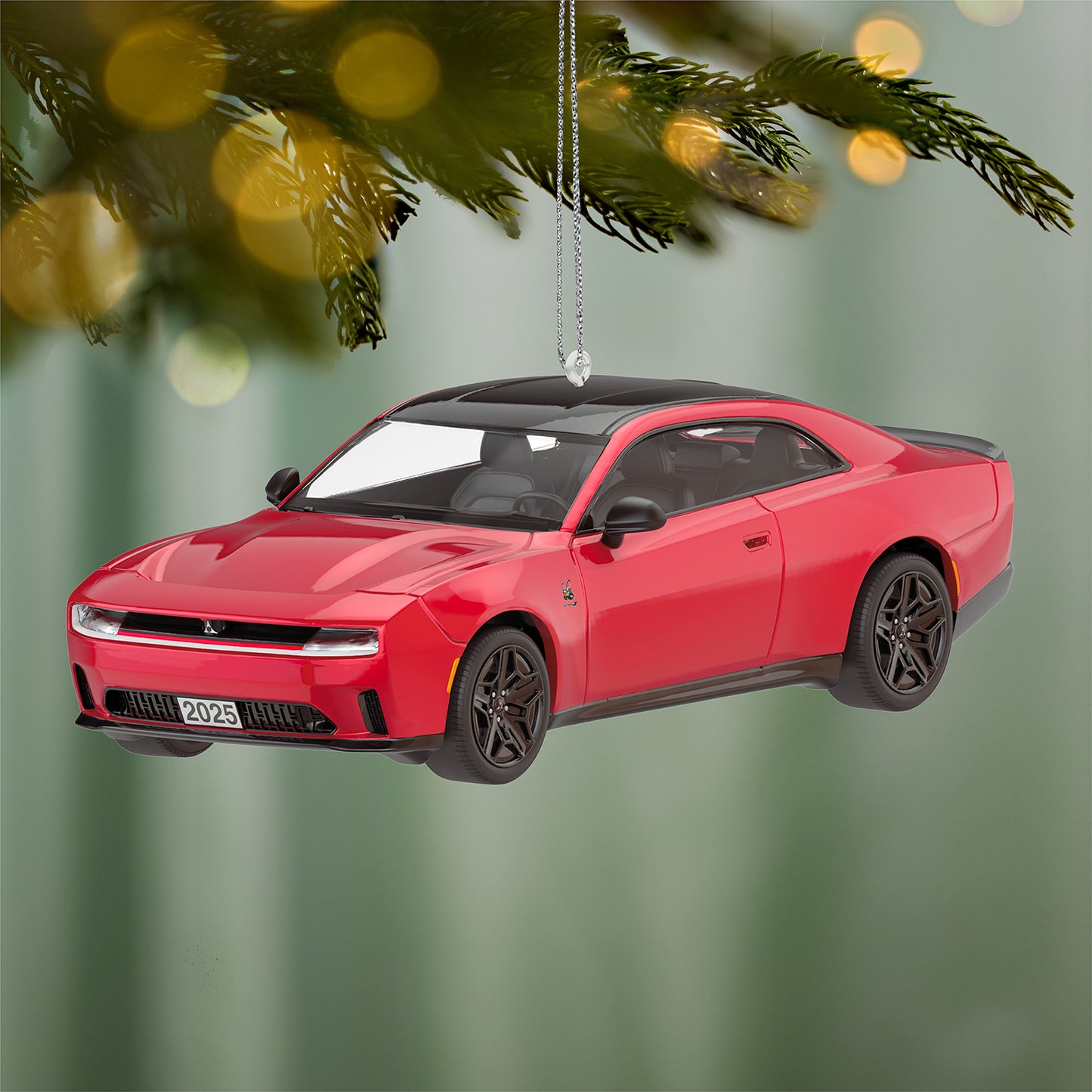 2025 Dodge Charger Daytona Scat Pack 2026, Metal — 2026 Hallmark Keepsake Christmas Ornament, fiery red design, hanging from a tree branch with blurred lights.