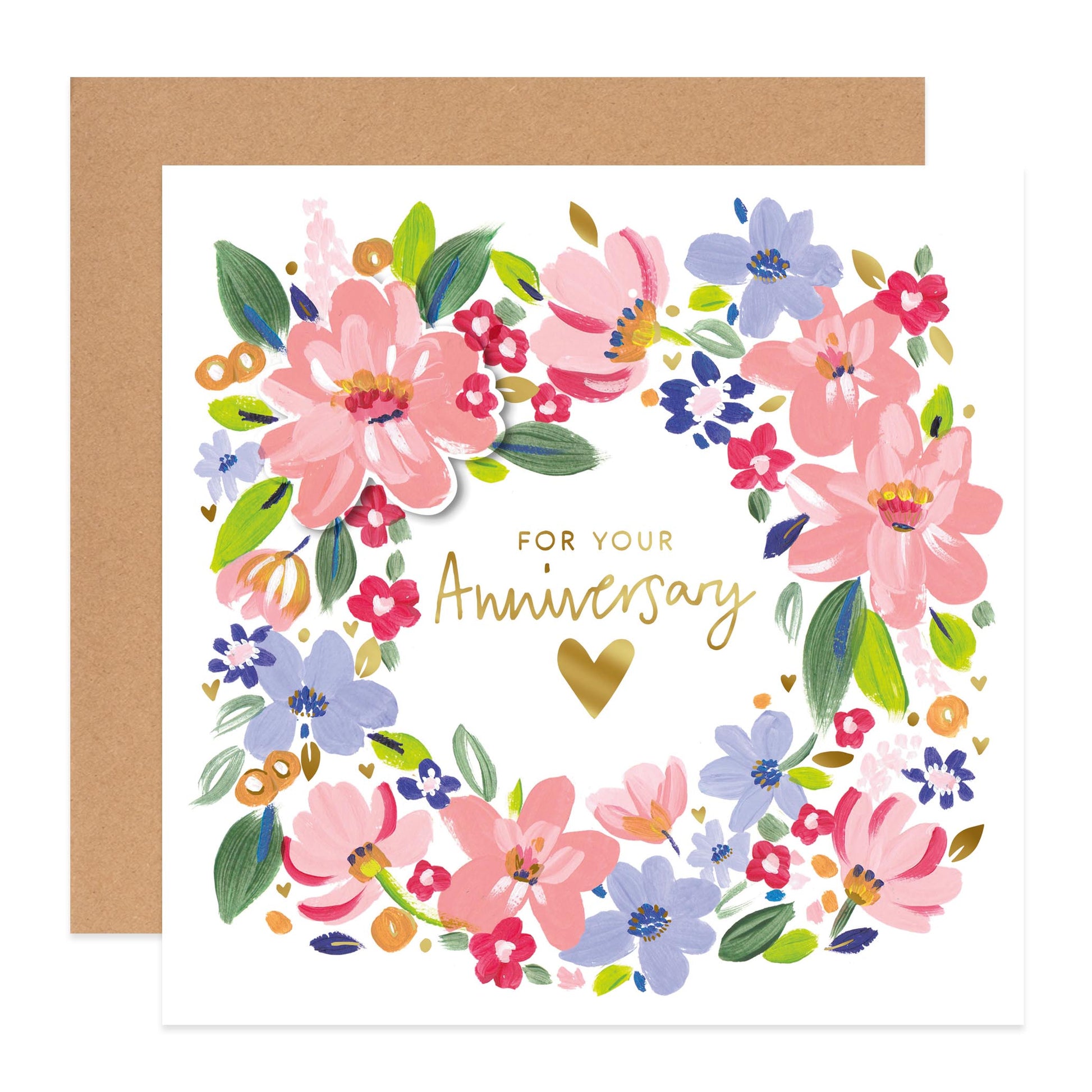 A square anniversary greeting card with a white front, featuring a colorful floral wreath illustration in pink, blue, green, and red, with gold script text reading 'FOR YOUR Anniversary' and a gold heart. A kraft brown envelope is placed behind the card on a white background.