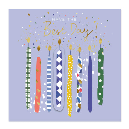 Square greeting card design with the text 'HAVE THE Best Day!' in white and gold above a row of illustrated patterned candles on a light lavender background.