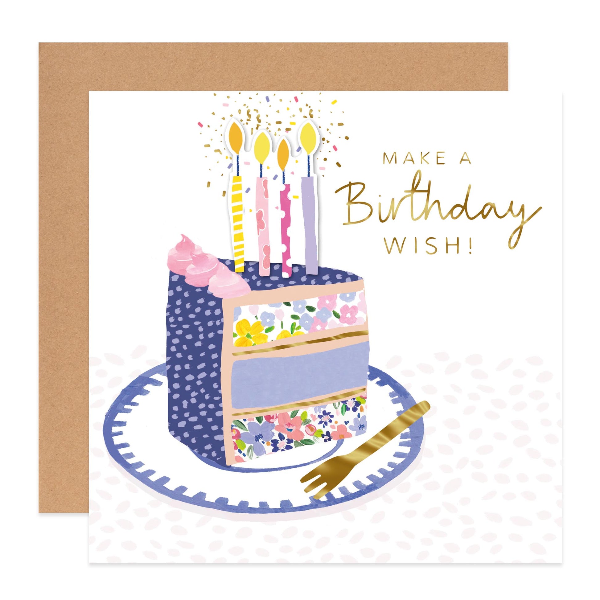 A birthday greeting card with an illustrated slice of cake, candles, confetti, and the words 'MAKE A Birthday WISH!' in gold script, shown with a kraft envelope behind it.