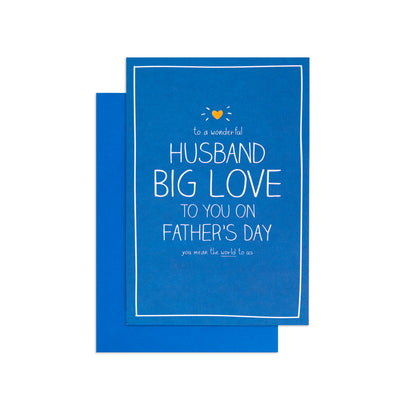 A blue greeting card with white text reading 'HUSBAND BIG LOVE TO YOU ON FATHER'S DAY' and a small yellow heart graphic, shown with a matching blue envelope on a white background.