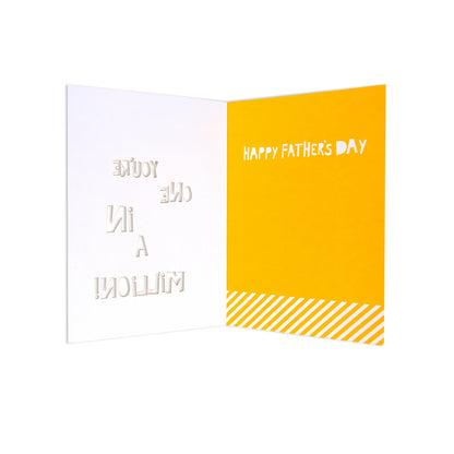 An open greeting card with a white left panel embossed with 'YOU ARE A MILLION' and a bright yellow right panel reading 'HAPPY FATHER'S DAY' above diagonal yellow stripes.