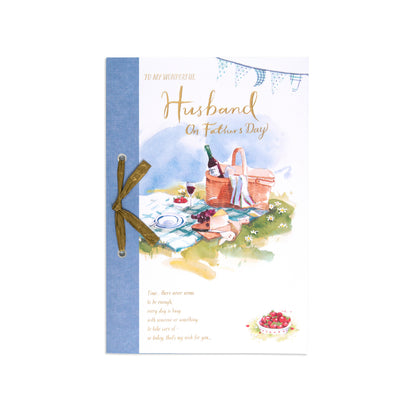Fcc Male Husband Picnic Lo card featuring an illustration of a picnic scene with a basket and wine, decorated with a blue ribbon.