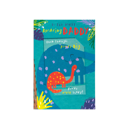 A rectangular greeting card with a colorful illustrated design, featuring the text 'To the most Amazing DADDY Even Though You're A little SCARY!' and a teal background with a red dinosaur and tropical leaves.