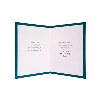 An open Father's Day greeting card with a dark teal border and white interior pages featuring short inspirational text and the words 'HAPPY FATHER'S DAY' in dark teal and light pink.