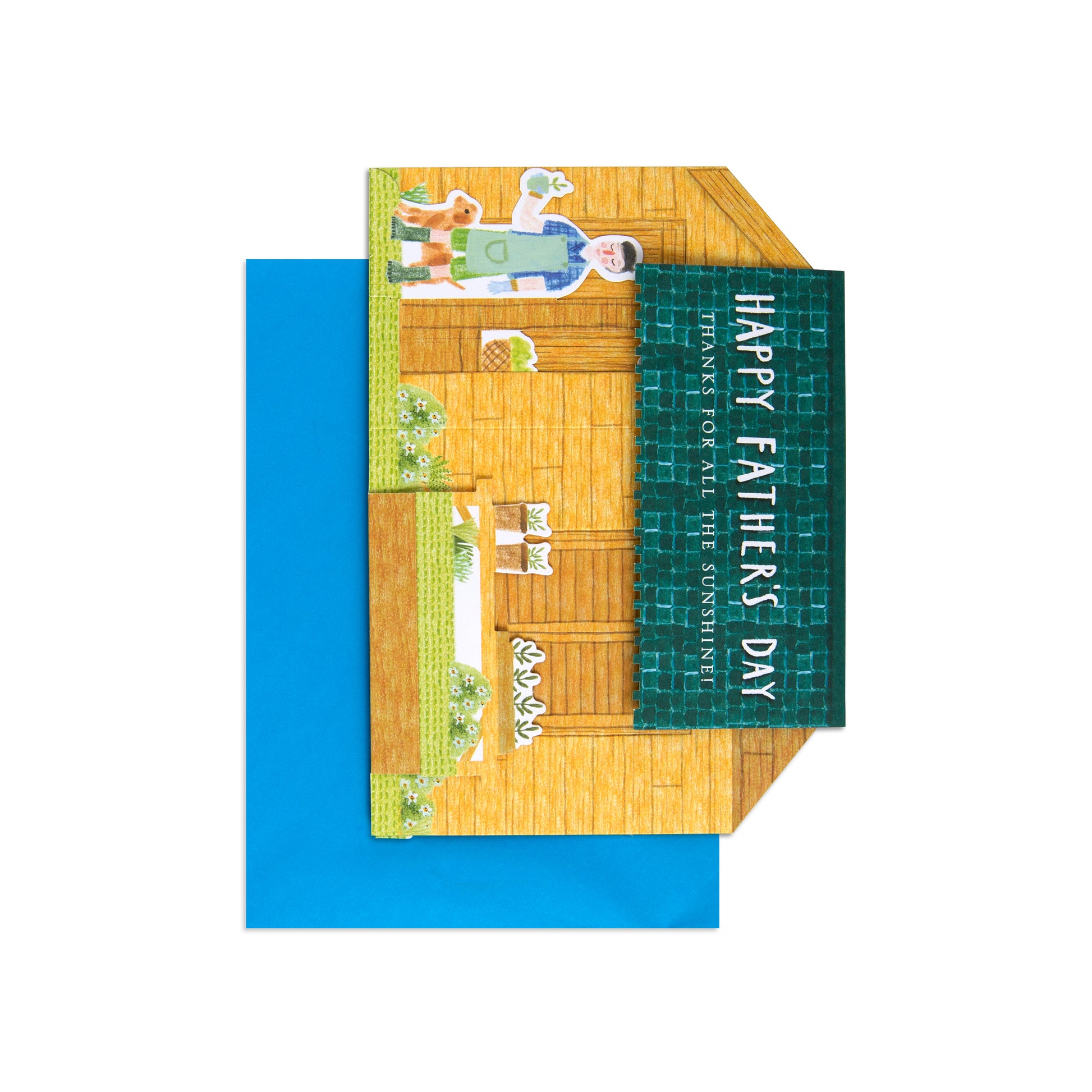 A folded greeting card with a colorful illustrated house scene and a dark green vertical panel reading 'HAPPY FATHER'S DAY' and 'PLANETS OF ALL THE GOURMETS,' shown with a bright blue envelope on a white background.