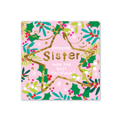 Hallmark Christmas card for sister - Amazing Wish with colourful holly and star illustrations, gold foil text on pink background.