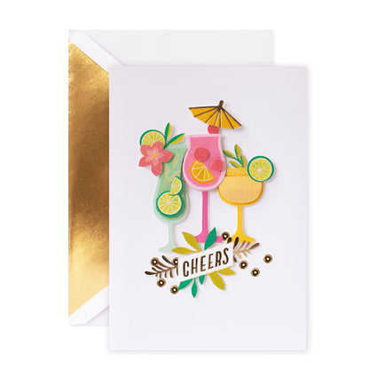 Hallmark Signature Celebration Card - Cheers! featuring tropical drink illustrations and gold foil accents, flat lay view.