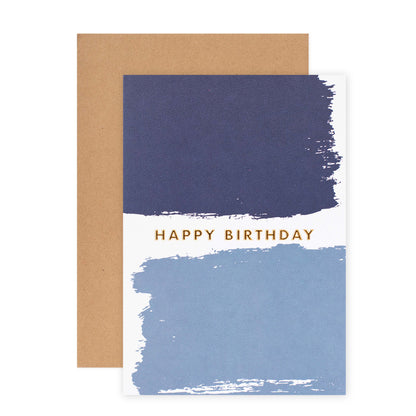 Halcyon by Hallmark Birthday Card – Blue Brushstrokes with two brushstrokes and gold text on textured stock, flat lay with kraft envelope.