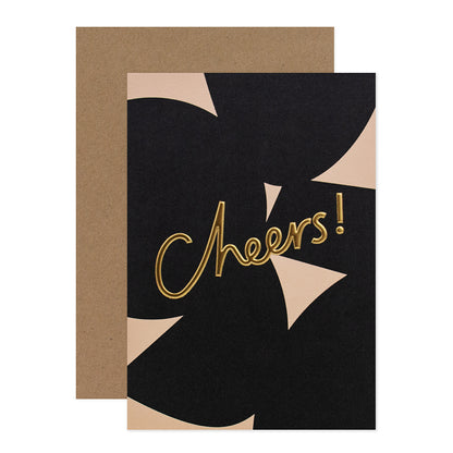 Halcyon by Hallmark All Occasion Card – Gold Typography Cheers! with a black and beige design and kraft envelope in flat lay