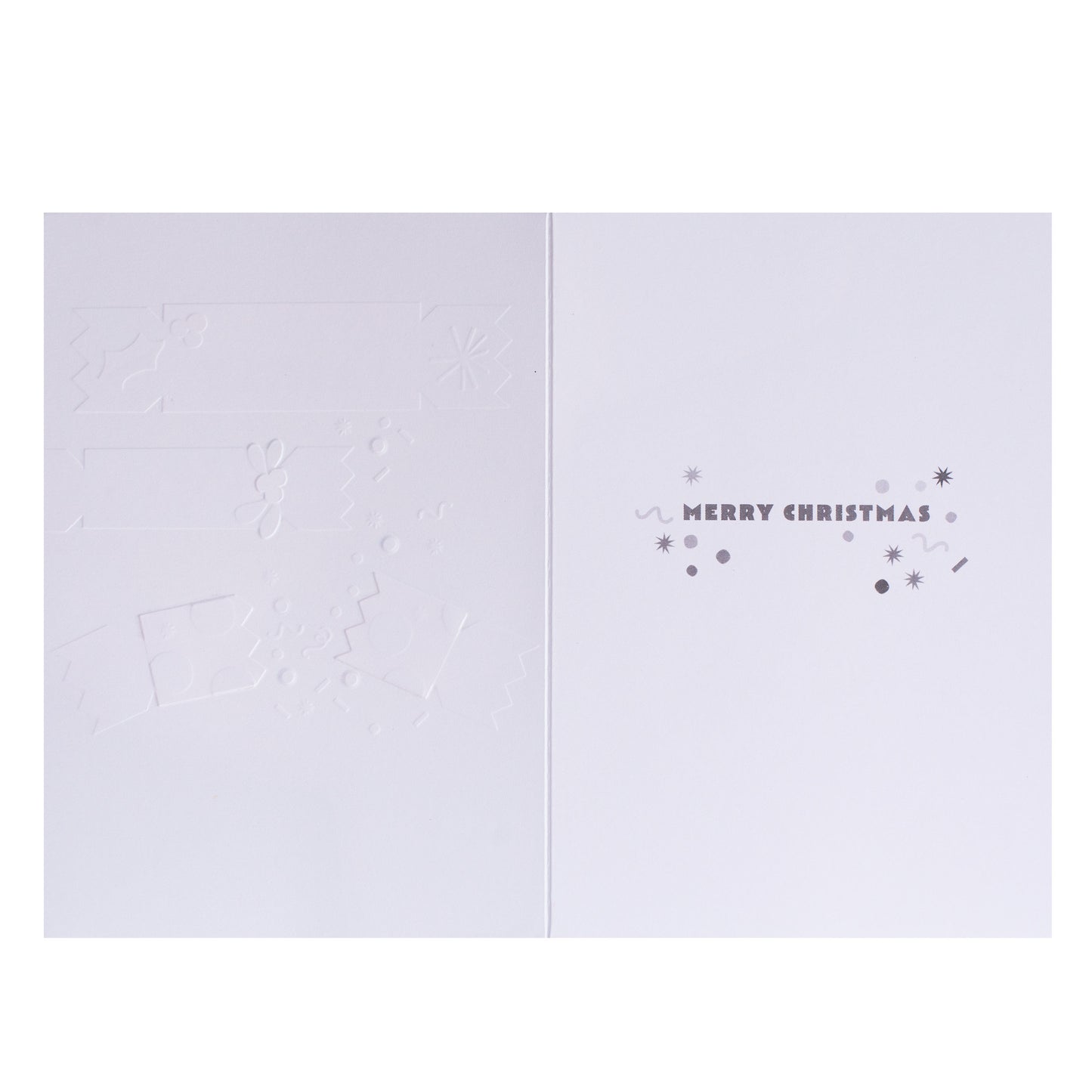 A minimalist white Christmas greeting card shown open, with embossed holiday motifs on the left panel and the right panel reading “MERRY CHRISTMAS” in small gray lettering with decorative dots and stars.