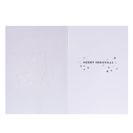 A minimalist white Christmas greeting card shown open, with embossed holiday motifs on the left panel and the right panel reading “MERRY CHRISTMAS” in small gray lettering with decorative dots and stars.