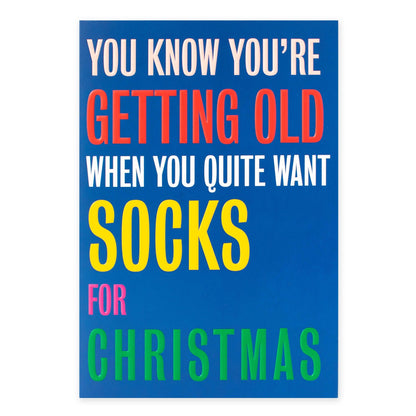 Hallmark Christmas Card - Socks with colourful embossed text expressing humorous sentiment, flat lay view.