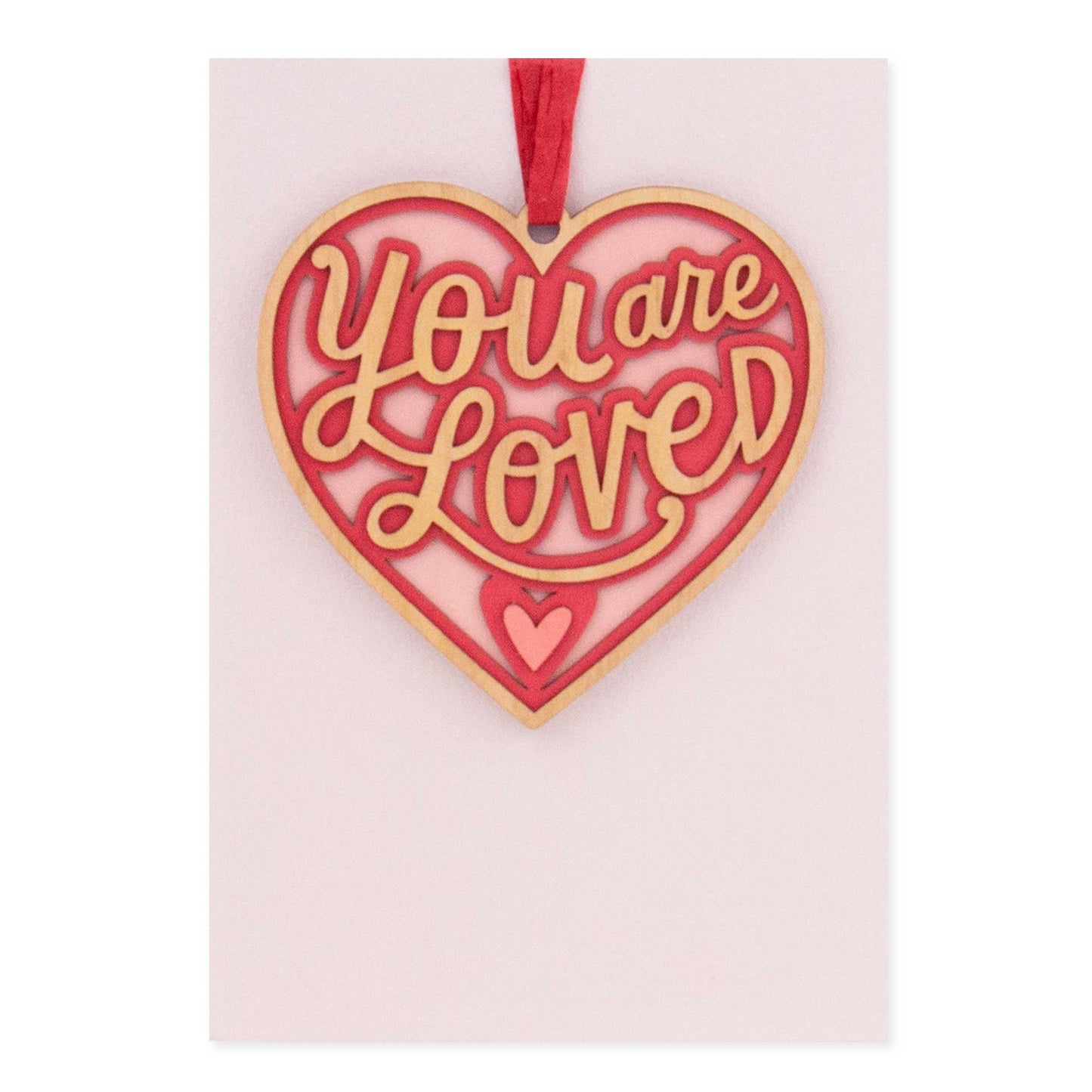 Hallmark Signature Valentine's Day Card - You Are Loved features a detachable heart ornament in red and gold with a pink background.