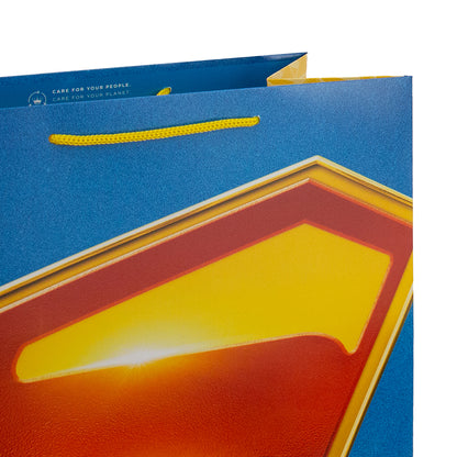 Hallmark Giftbag - Large Superman Shield in vibrant blue with yellow accents and a glossy finish, angled view showcasing details.