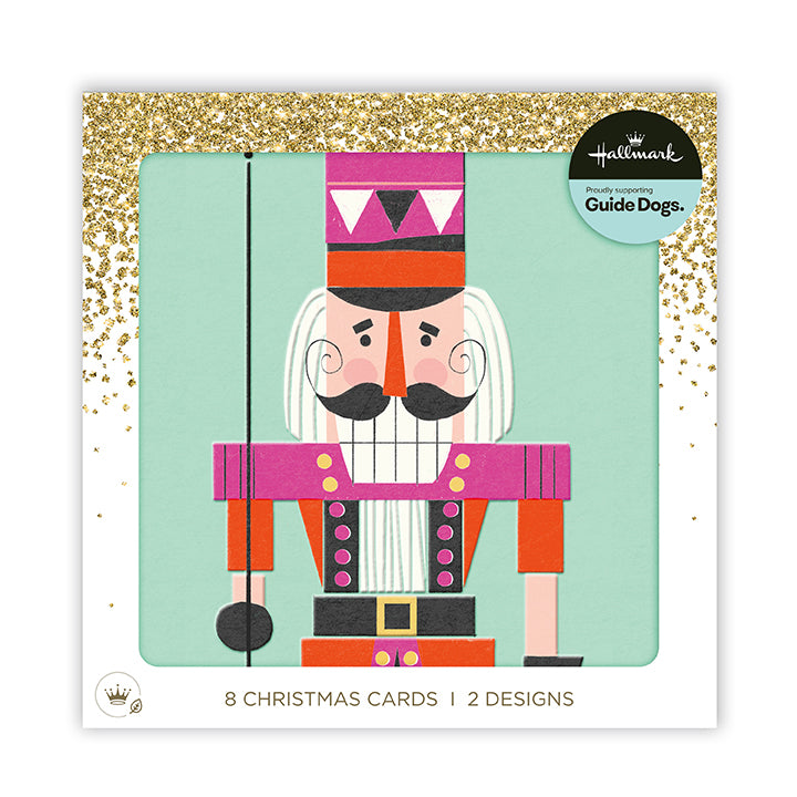 Hallmark Christmas Cards 'Guide Dogs.' package featuring a stylized nutcracker illustration on a mint background with gold glitter corner accents and text reading '8 Christmas Cards 1 Designs'.