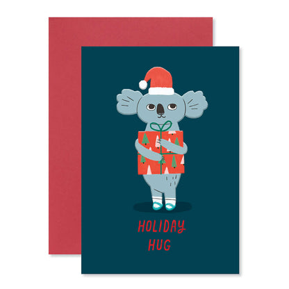 Hallmark Christmas card - Koala Hug featuring a koala in a Santa hat holding a gift with a red envelope, cute illustration.