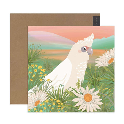 Hallmark x Christie Williams Gallery Blank Greeting Card - Grassland featuring a white cockatoo surrounded by daisies and greenery in a colourful illustration.