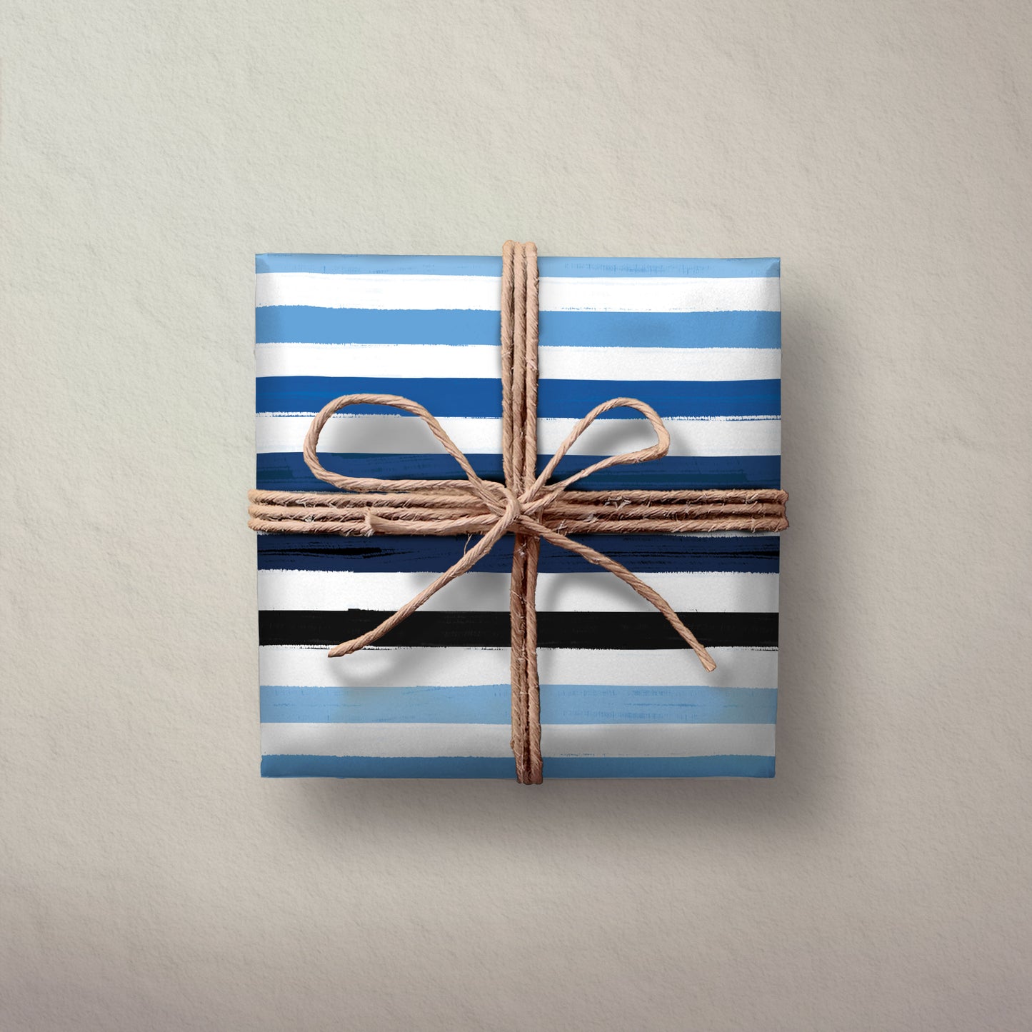 Hallmark Flat Wrapping Paper - Blue Brushstrokes gift wrapped box in blue and black stripes, tied with natural twine on a textured background.