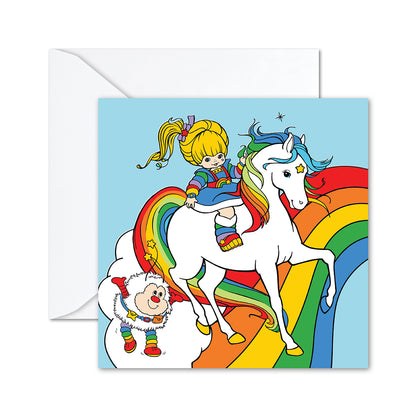 Hallmark Rainbow Brite Greeting Card featuring Rainbow Brite riding Starlite with Twink on a vibrant rainbow background, flat lay view.