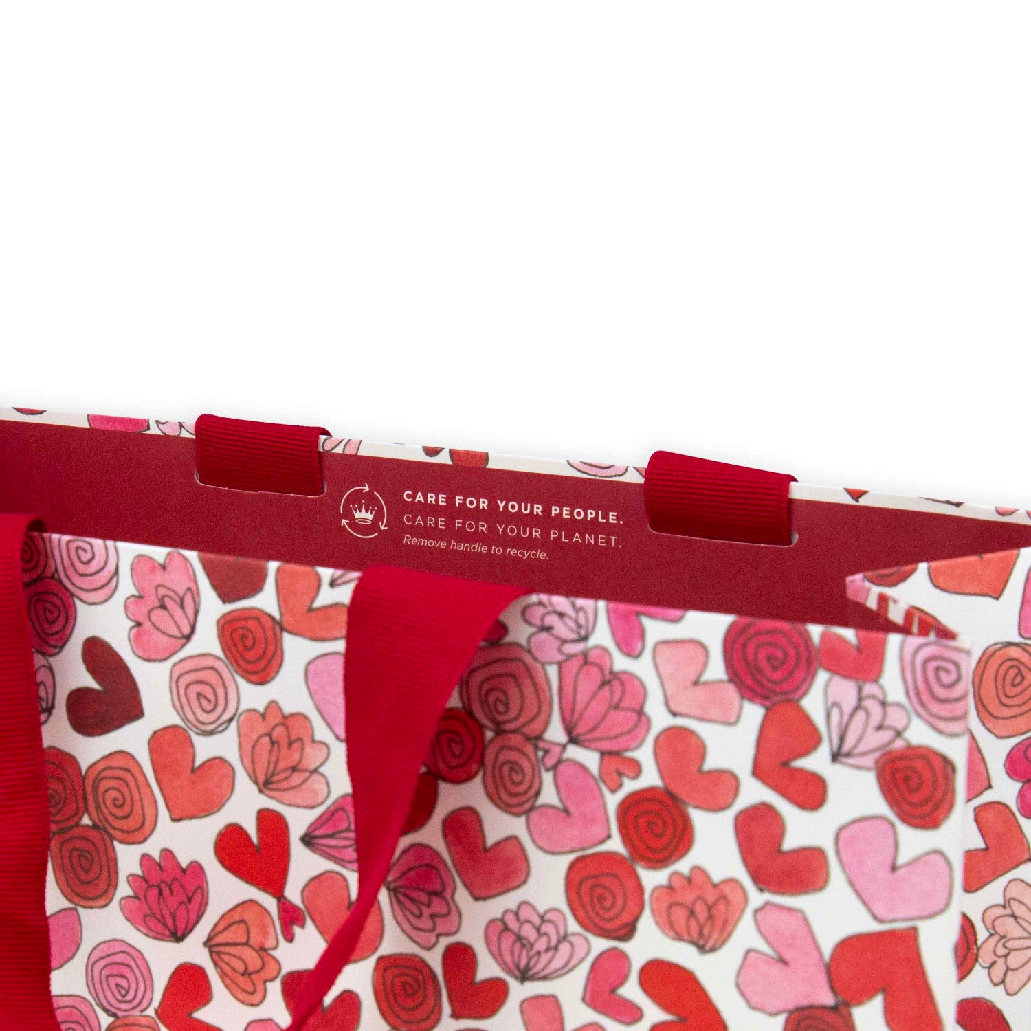 Hallmark x Love, Meredith Large Gift Bag - Hearts & Flowers featuring red grosgrain ribbon handles and pink and red heart illustrations, close up view.