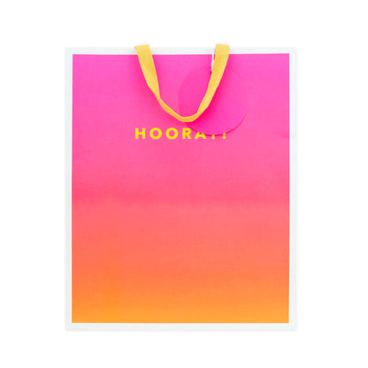 A square shopping bag with a vibrant pink to orange gradient design and yellow handles, featuring the text 'HOORA!' in yellow on the front.