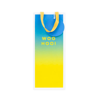 A vertical yoga mat with a blue-to-yellow gradient design and yellow handles, featuring the text 'WOO HOO!' in yellow on the front.