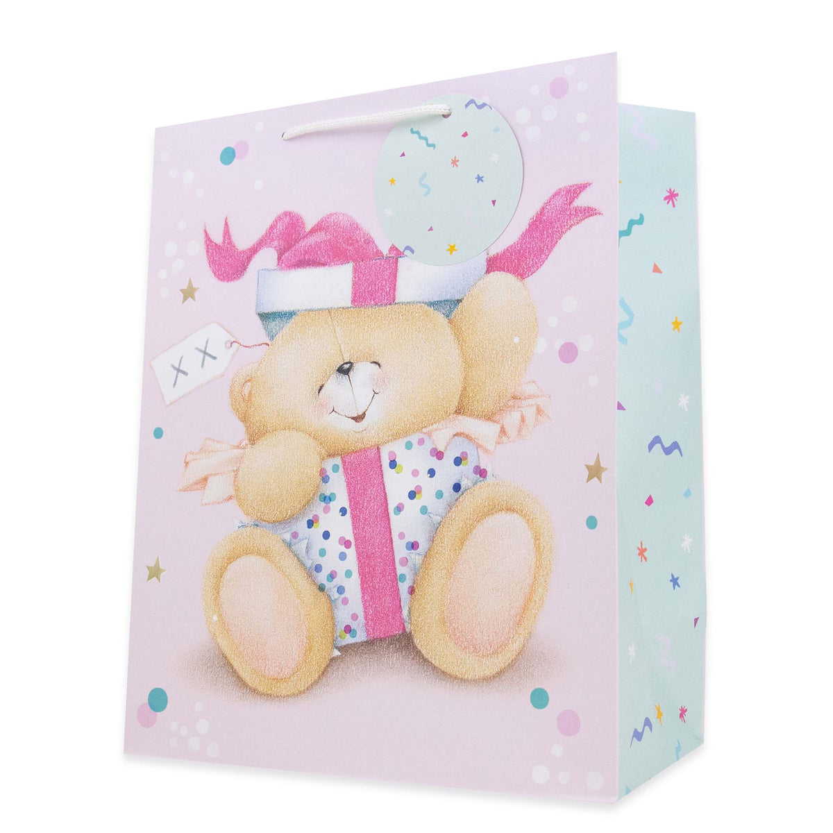 A pastel pink gift bag featuring a teddy bear illustration wearing a party hat and holding a wrapped gift, with confetti and polka dot details on a clean white background.