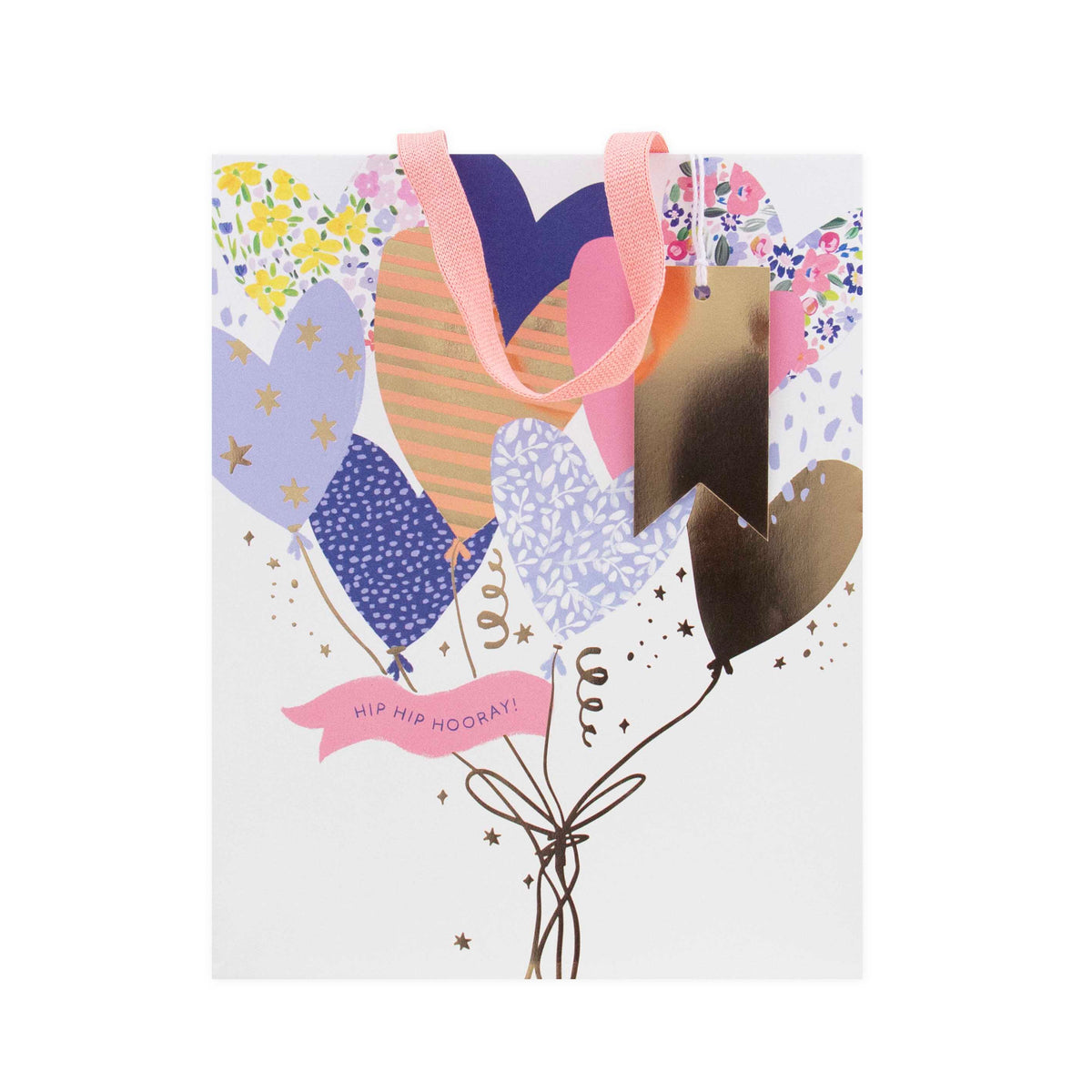 A white gift bag decorated with a festive balloon bouquet illustration. The design features metallic gold foil hearts, pastel patterned balloons in purple, blue, and orange, a pink ribbon handle, and a pink banner that reads 'HIP HIP HOOMAY!'.