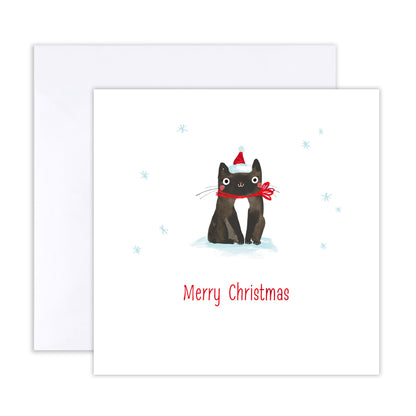 A square Christmas greeting card with a white envelope behind it. The card features an illustration of two black cats sitting in snow, one wearing a red Santa hat and the other a red Santa scarf, with the text 'Merry Christmas' printed below in red.
